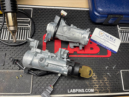 Two automotive ignitions on a Noble Locksmith work table.